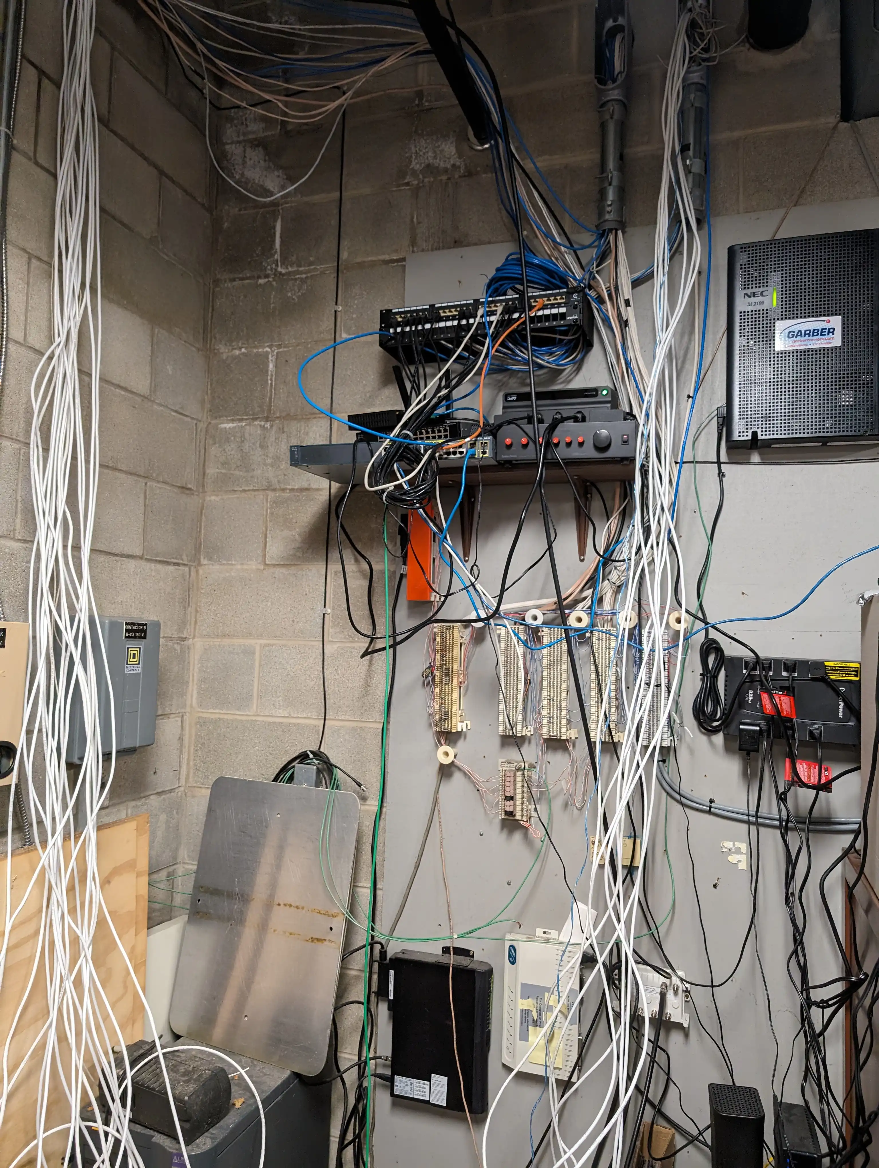 Close-up view of complex wiring junction and patch panel showing existing infrastructure at Springfield Family YMCA requiring integration with new structured cabling